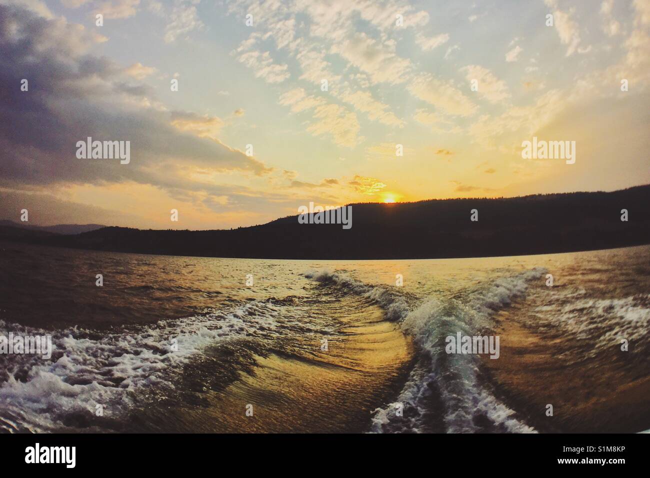 Summer sunset over lake with mountains in the distance. - Smartphone Captured Stock Image
