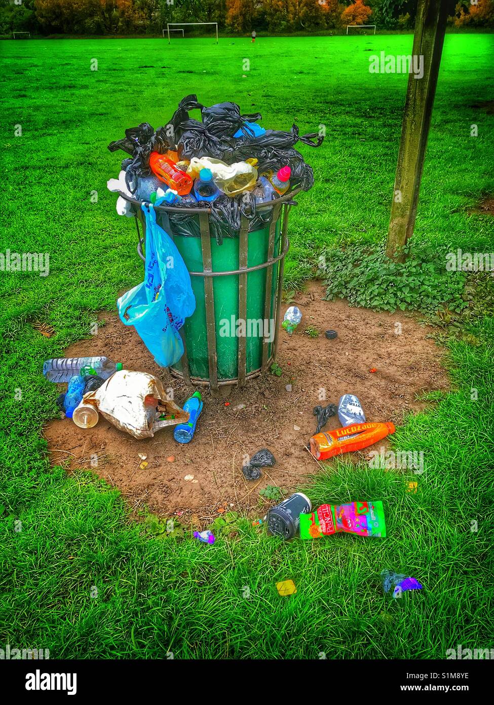 Rubbish bin in a local park that is overflowing with waste Stock Photo