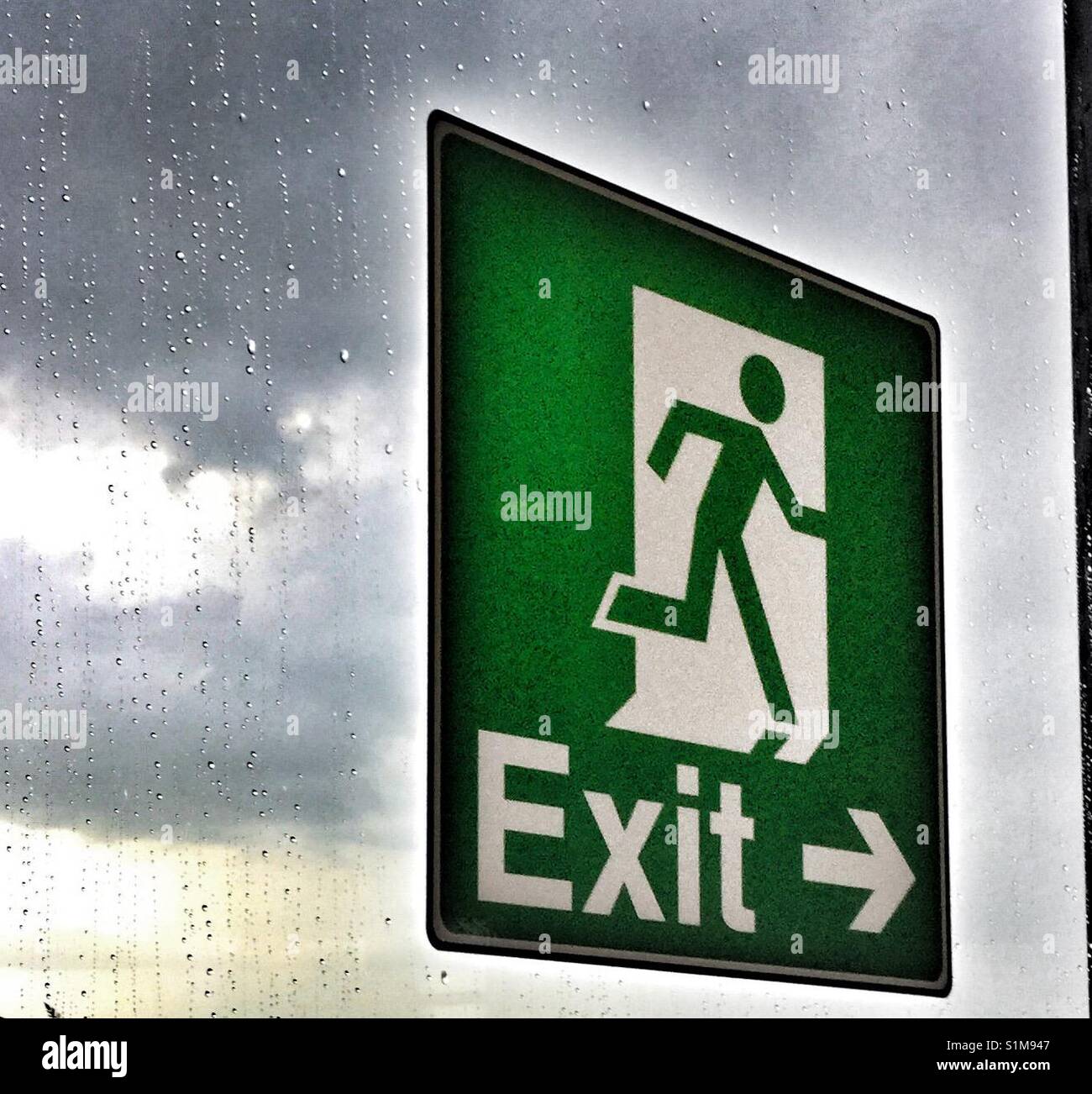 Green exit sign on a window. - Smartphone Captured Stock Image