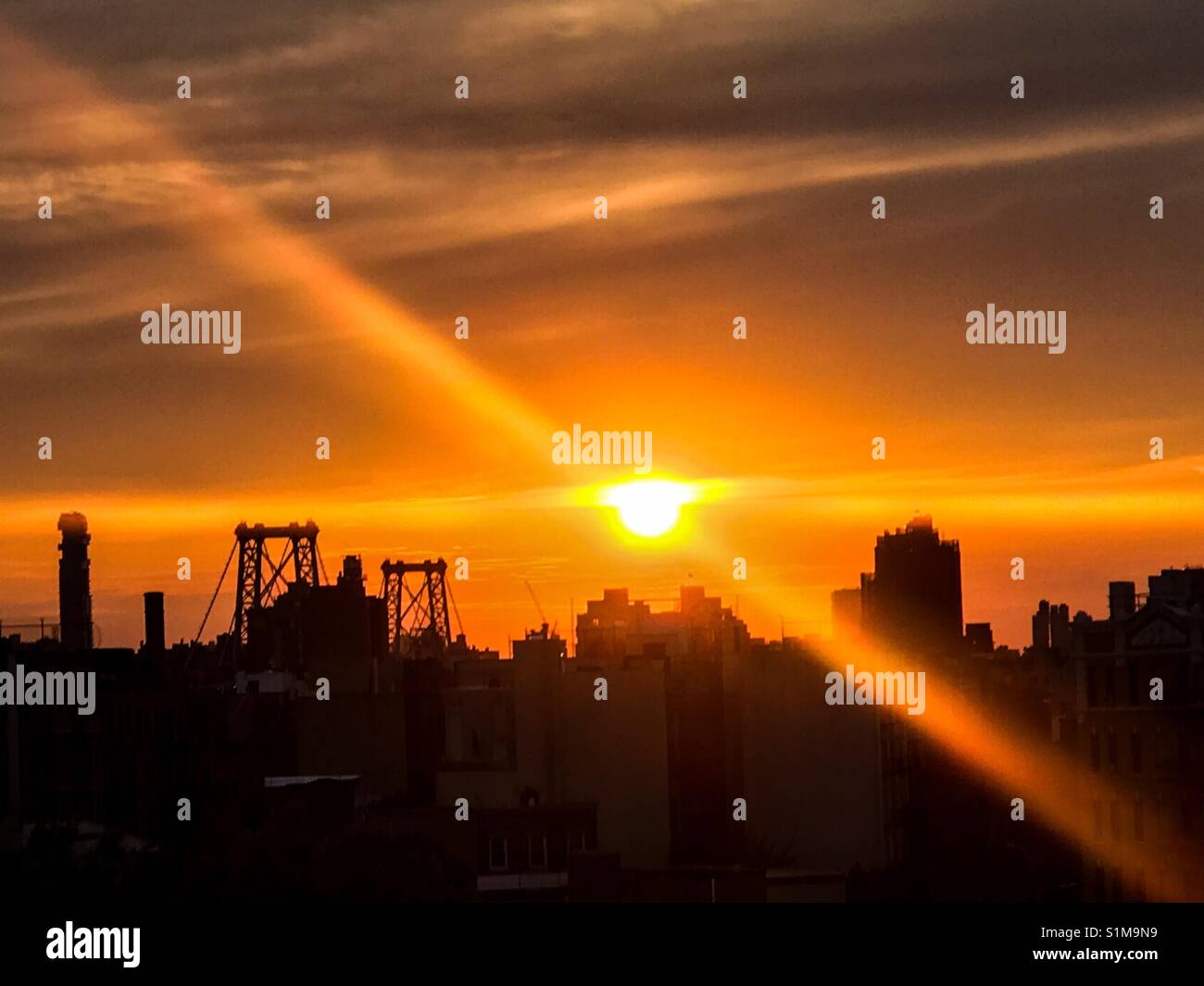 Sunset over Lower Manhattan from a window in Williamsburg, Brooklyn. - Smartphone Captured Stock Image