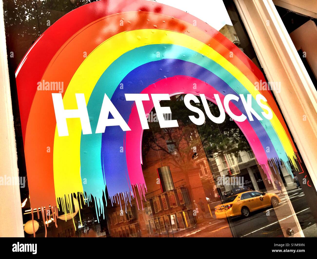 Hate sucks and rainbow sign on store window, NYC, USA - Smartphone Captured Stock Image
