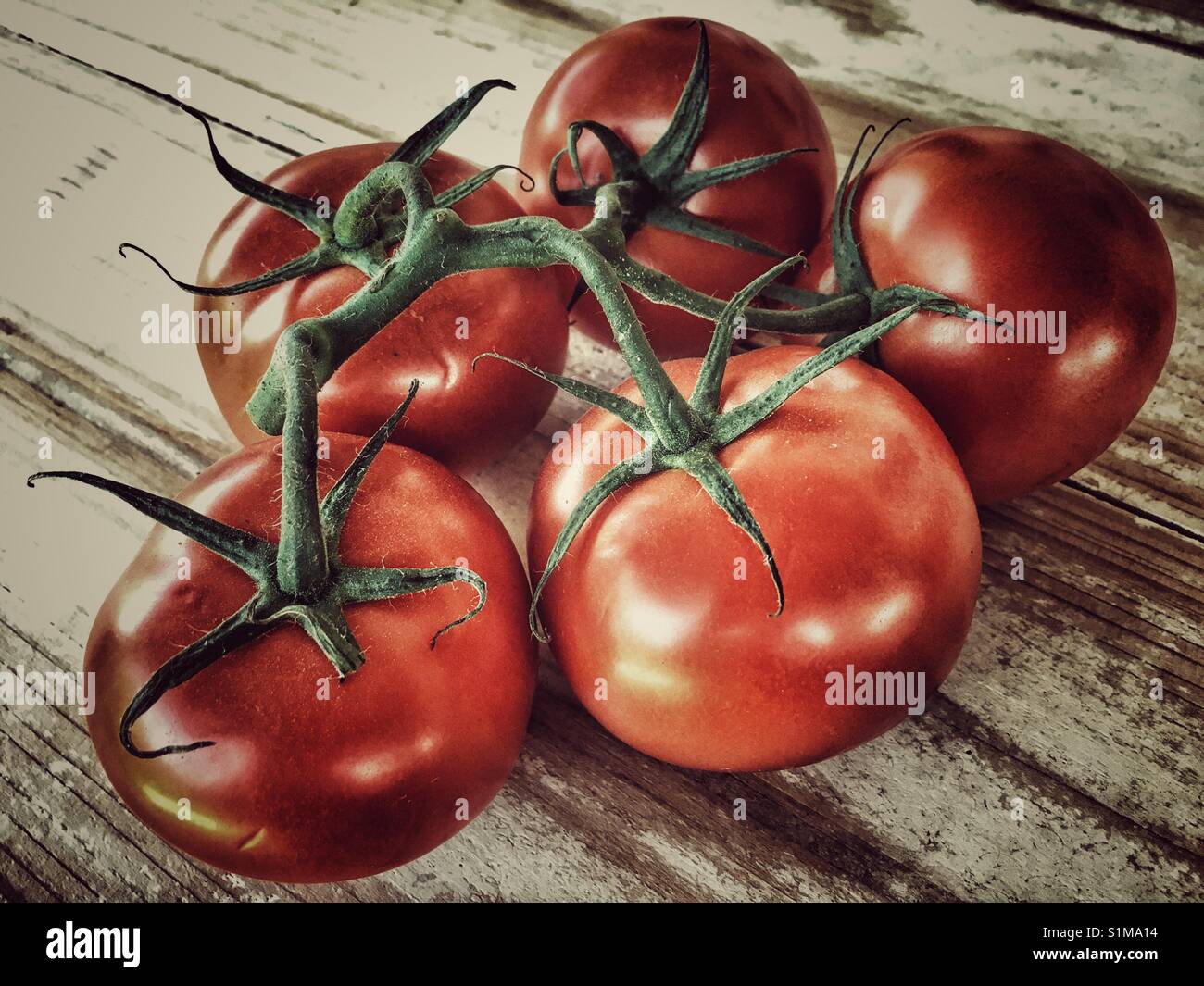 Vine tomatoes on a wooden table - Smartphone Captured Stock Image