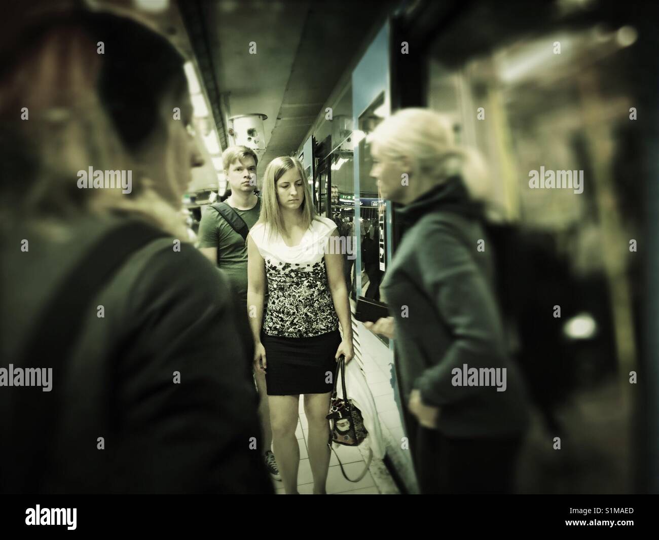 Young woman about to enter and board subway, metro, tube train in Stockholm - Smartphone Captured Stock Image
