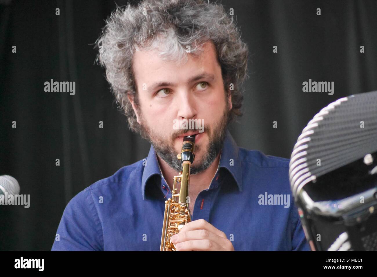 Male musician with salt and pepper hair playing clarinet Stock Photo