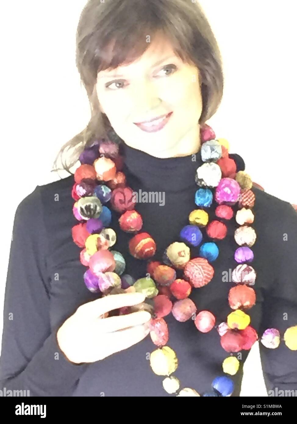 Beautiful young woman showing off her new fabric necklace. - Smartphone Captured Stock Image