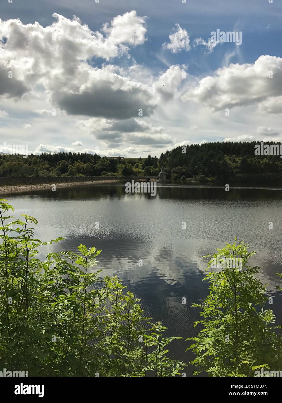 Ponsticill reservoir, near Merthyr Tydfil, Wales - August 2017: Scenic view of the still waters of the reservoir looking towards the wall of the dam Stock Photo