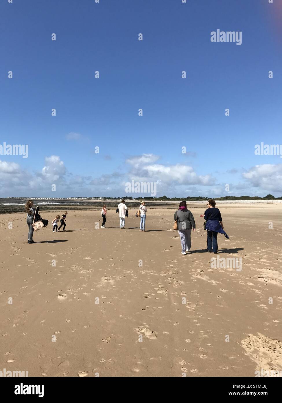 Newton Bay, Porthcawl, Wales- August 2017:  People enjoy a leisurely stroll on the quiet beach at low tide - Smartphone Captured Stock Image