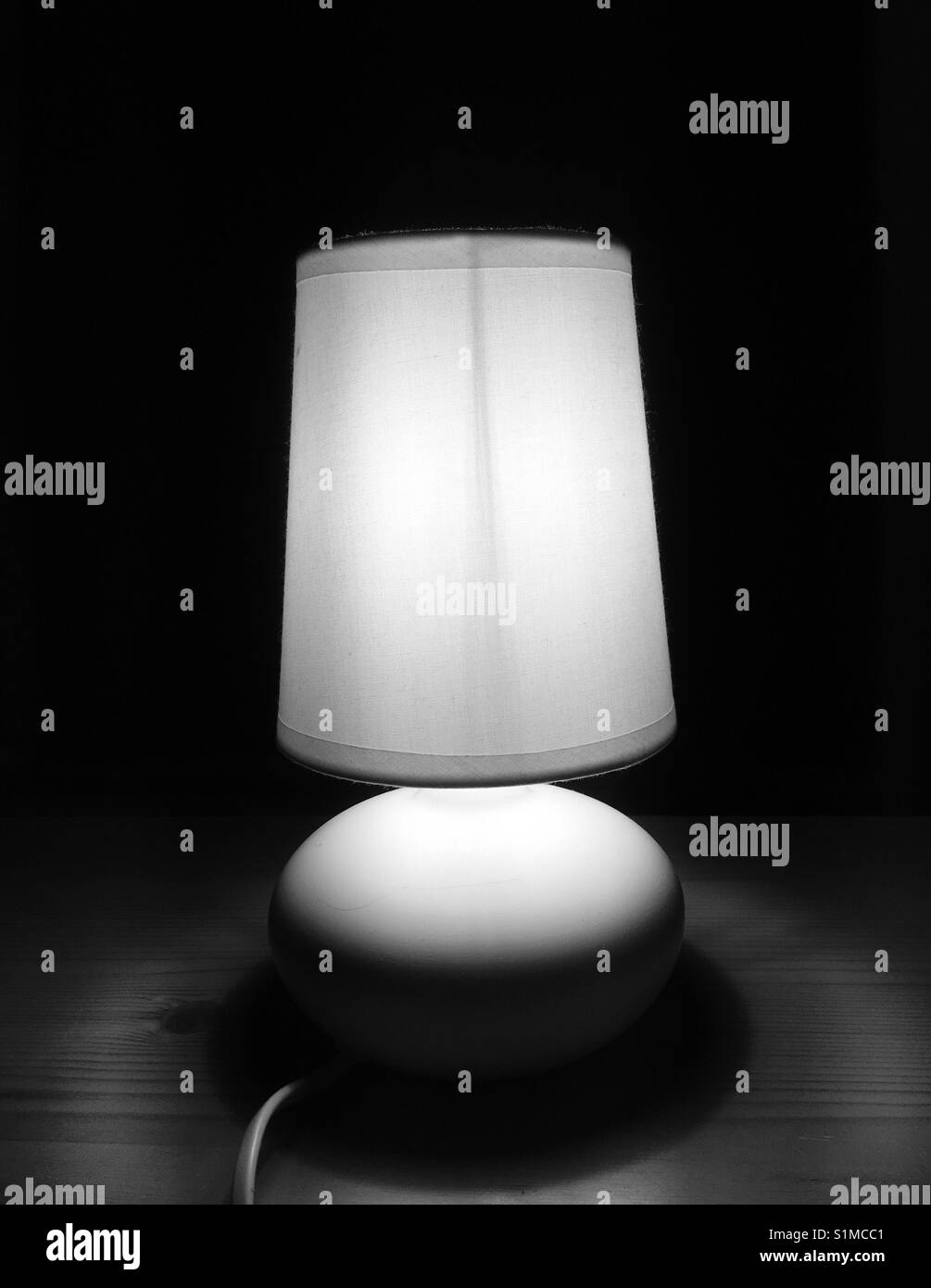 Night lamp on wooden nightstand black and white Stock Photo