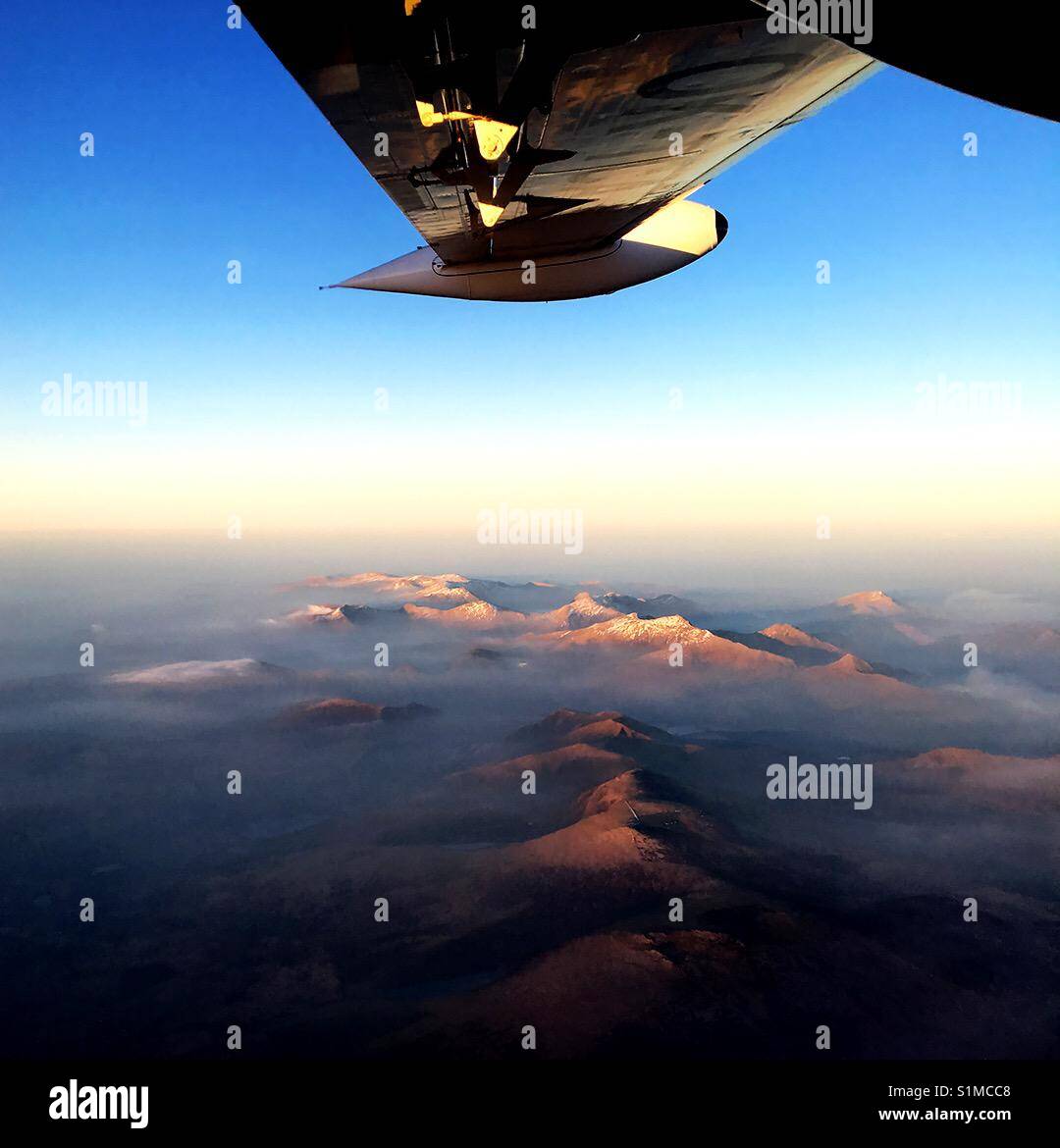 Wales -2016: An aerial view of the Snowdonia mountain range from a small commuter plane, with peaks showing between the clouds - Smartphone Captured Stock Image