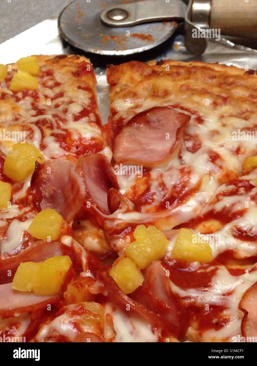 Pineapple and Canadian bacon pizza -sliced and ready to eat Stock Photo