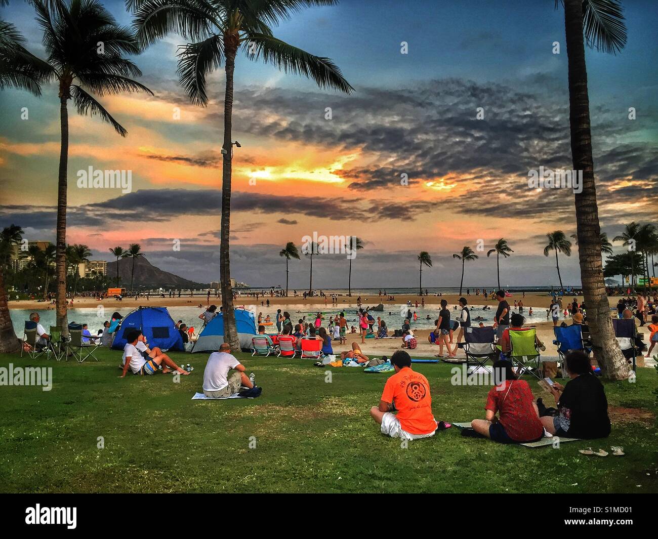 Locals and tourist gather beachside to watch the Friday night fireworks at Waikiki, Oahu, Hawaii Stock Photo