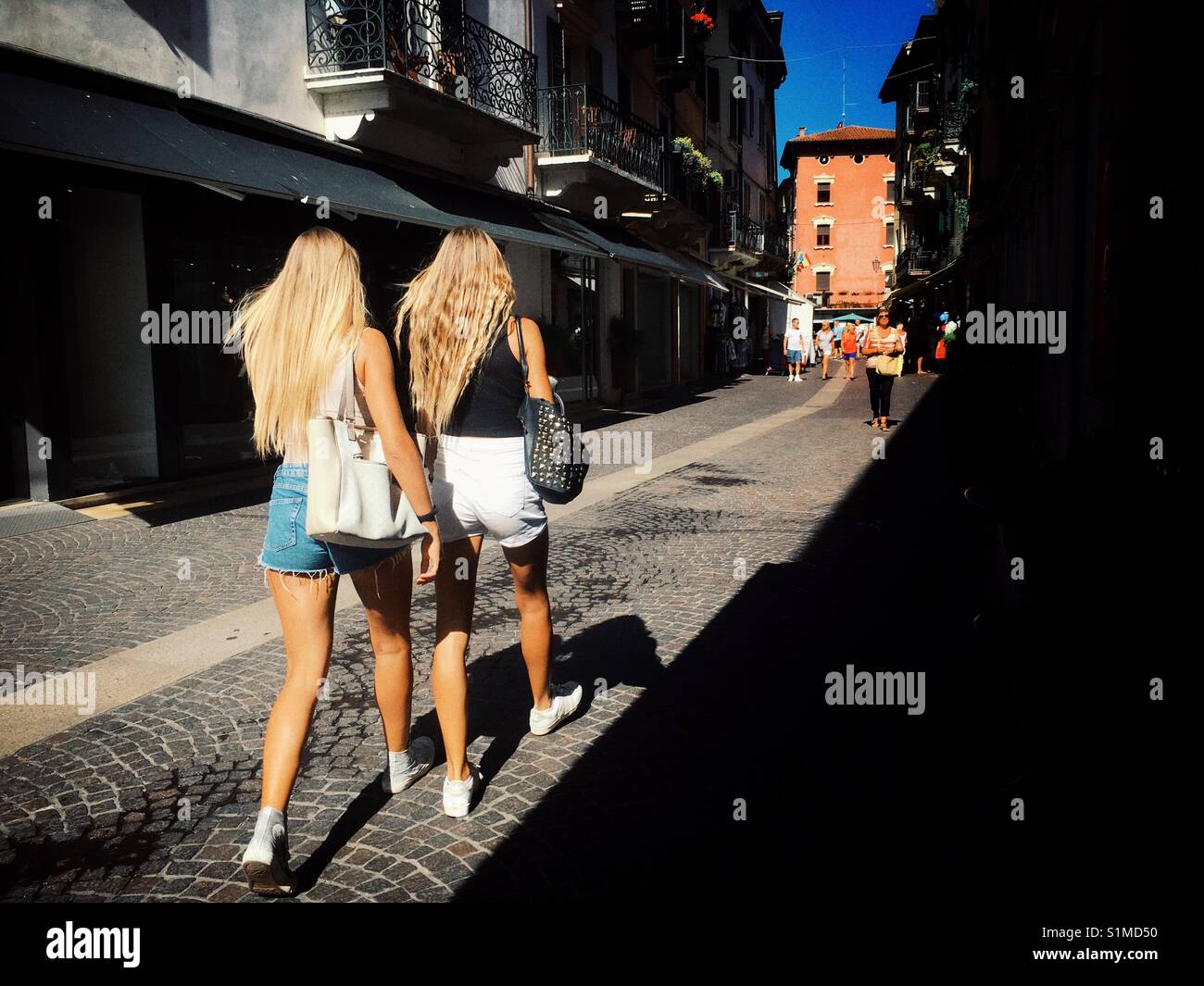 Two young women walk together in Italy - Smartphone Captured Stock Image