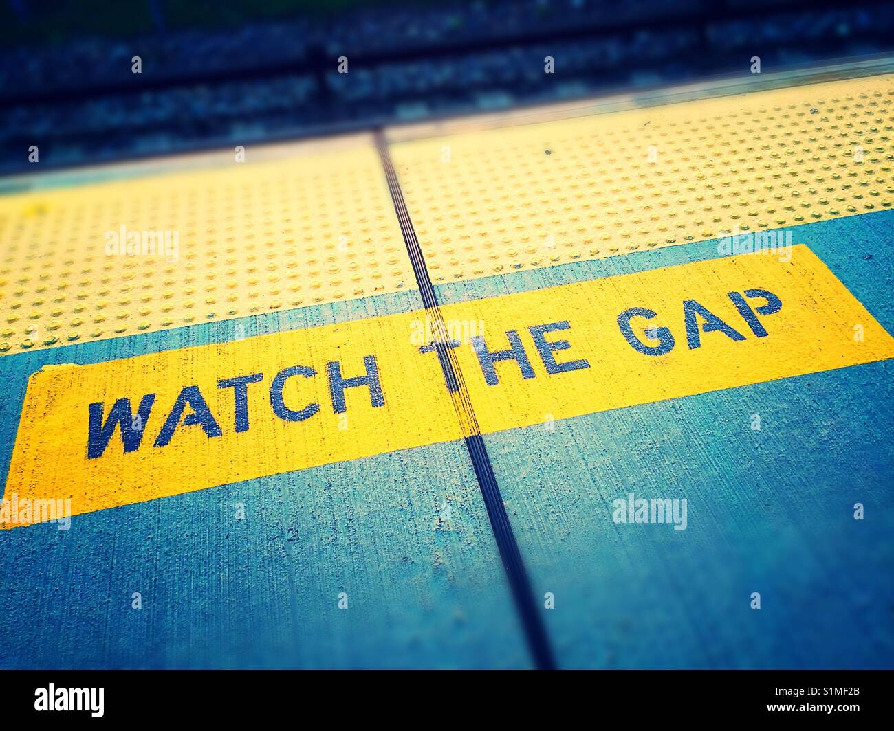 Train platform warning to watch the gap between the subway train and platform, NYC, USA - Smartphone Captured Stock Image