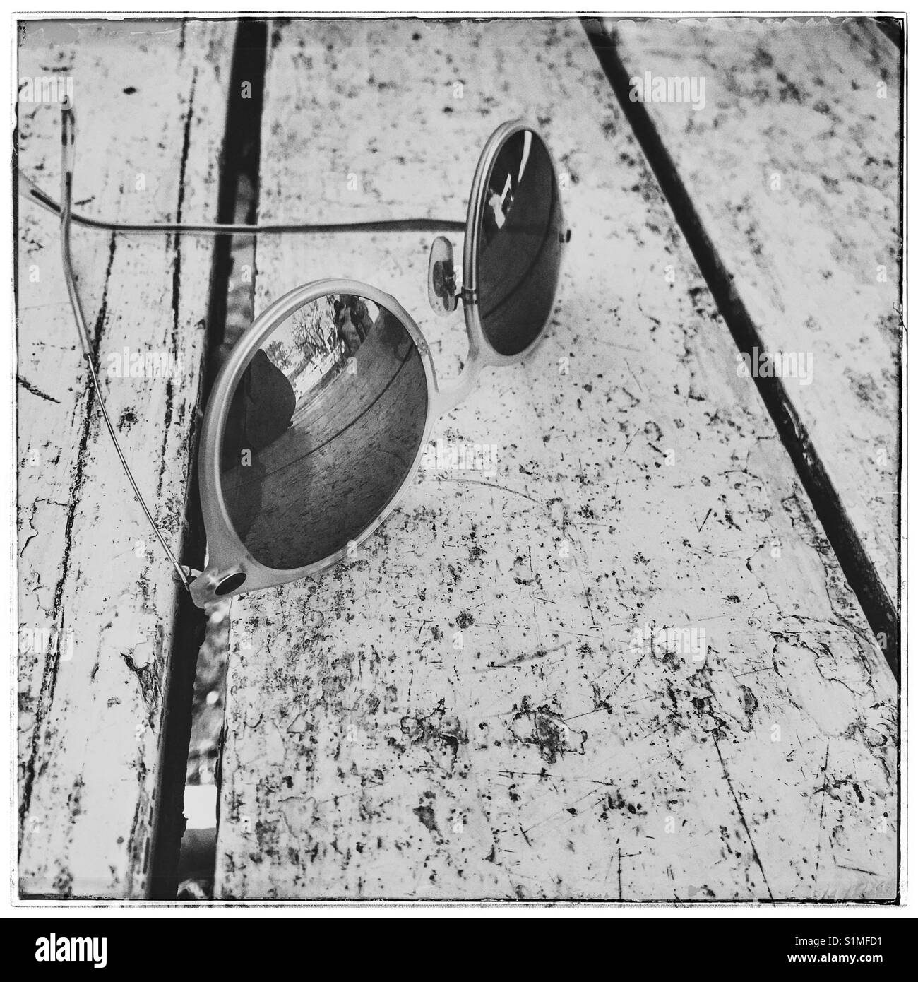 Black and white photo of sunglasses on table. - Smartphone Captured Stock Image