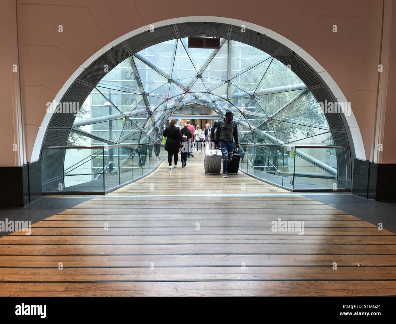Symmetry of glass covered walkway in shopping centre. Arndale Manchester UK - Smartphone Captured Stock Image