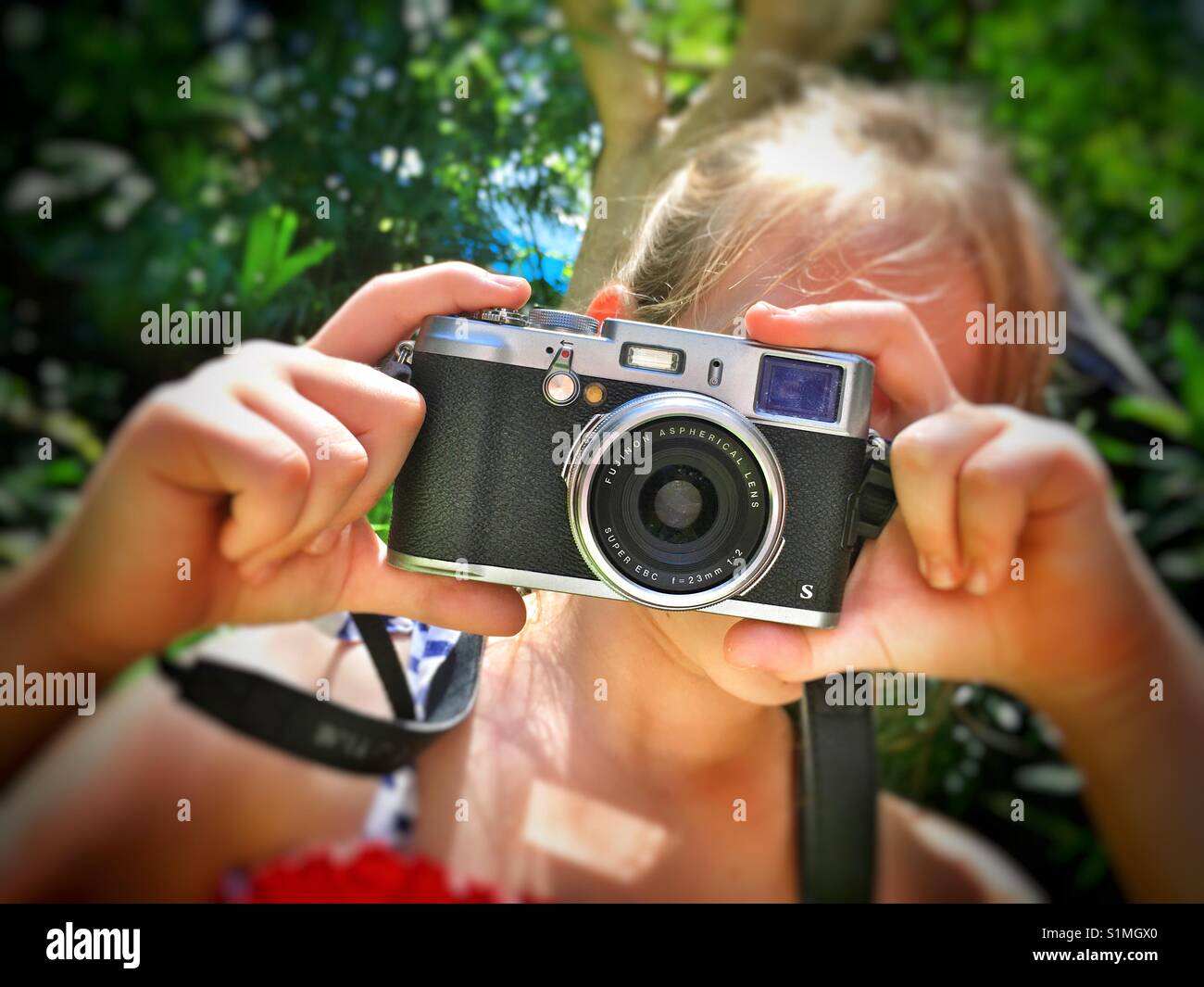 Girl taking a photograph with a Fuji digital camera. - Smartphone Captured Stock Image