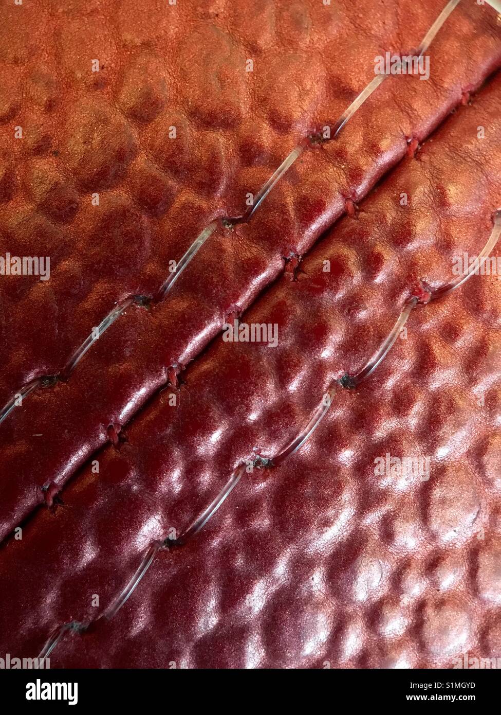 Closeup angled stitching on red vinyl pebble textured sofa Stock Photo ...