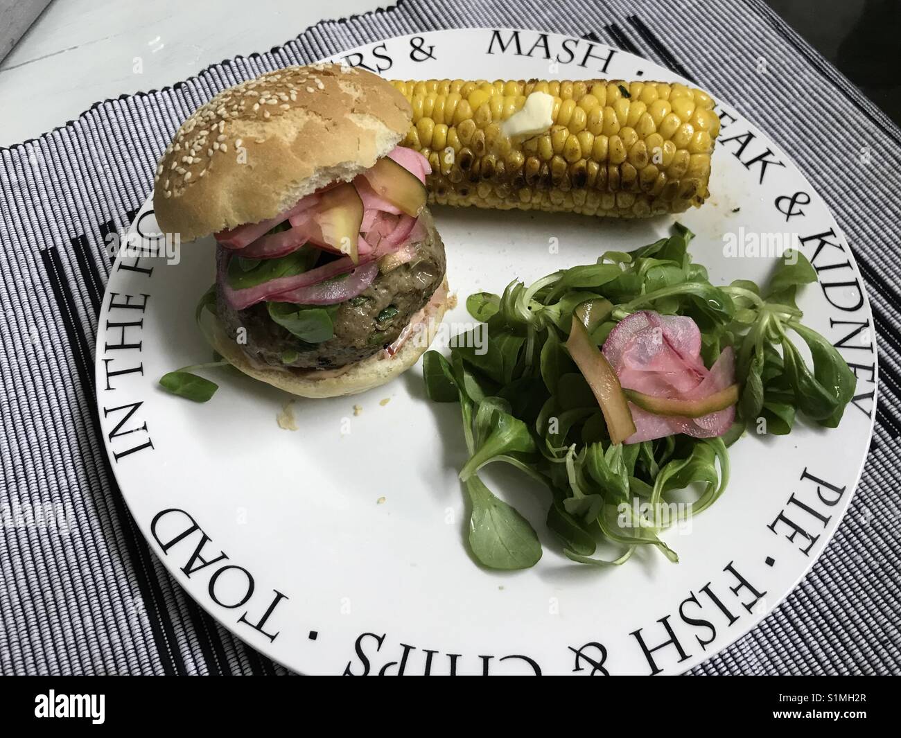Homemade burger delight, with corn on the cob! Stock Photo