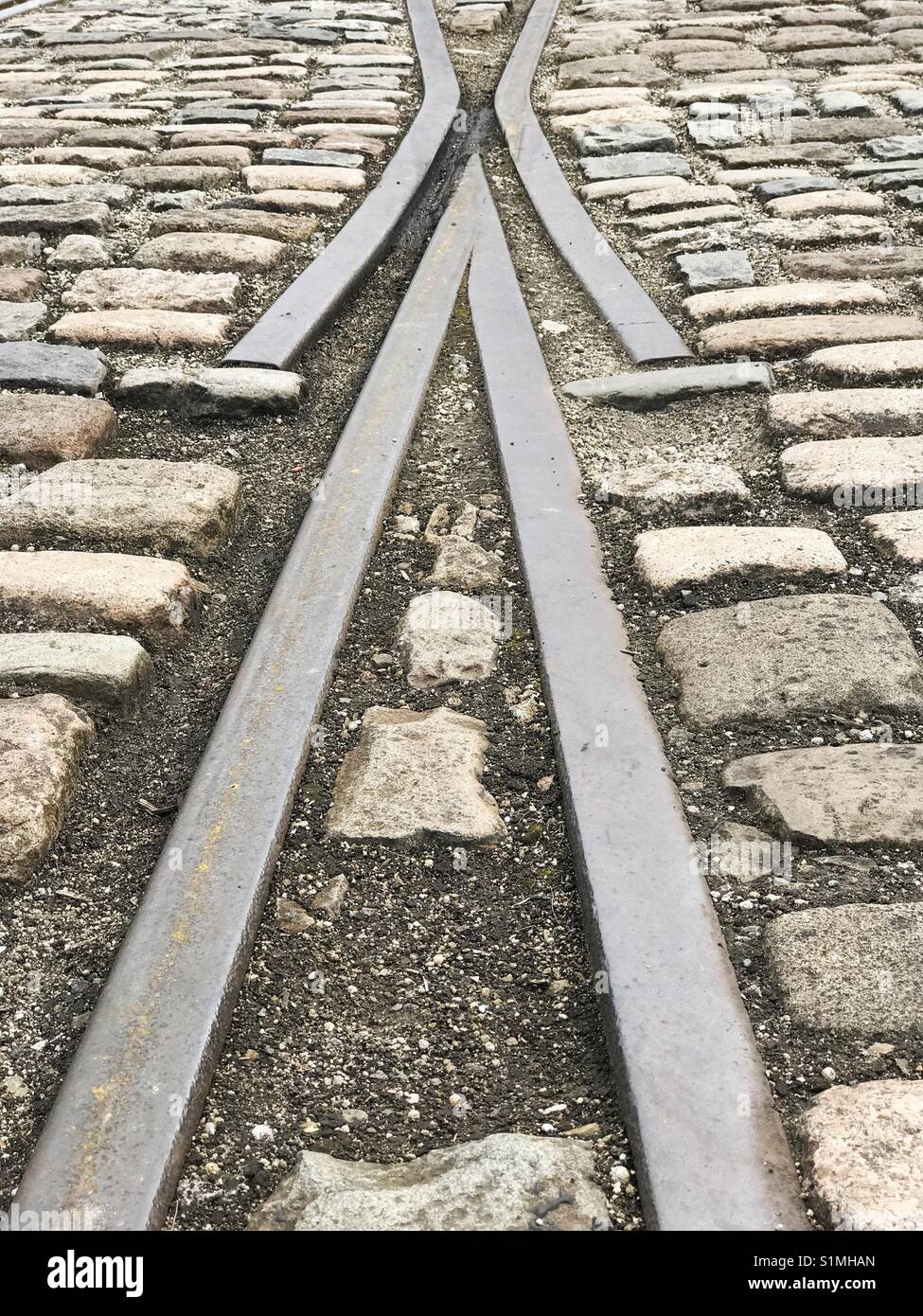 Shapes and lines of rail tracks set in cobbled stones - Smartphone Captured Stock Image