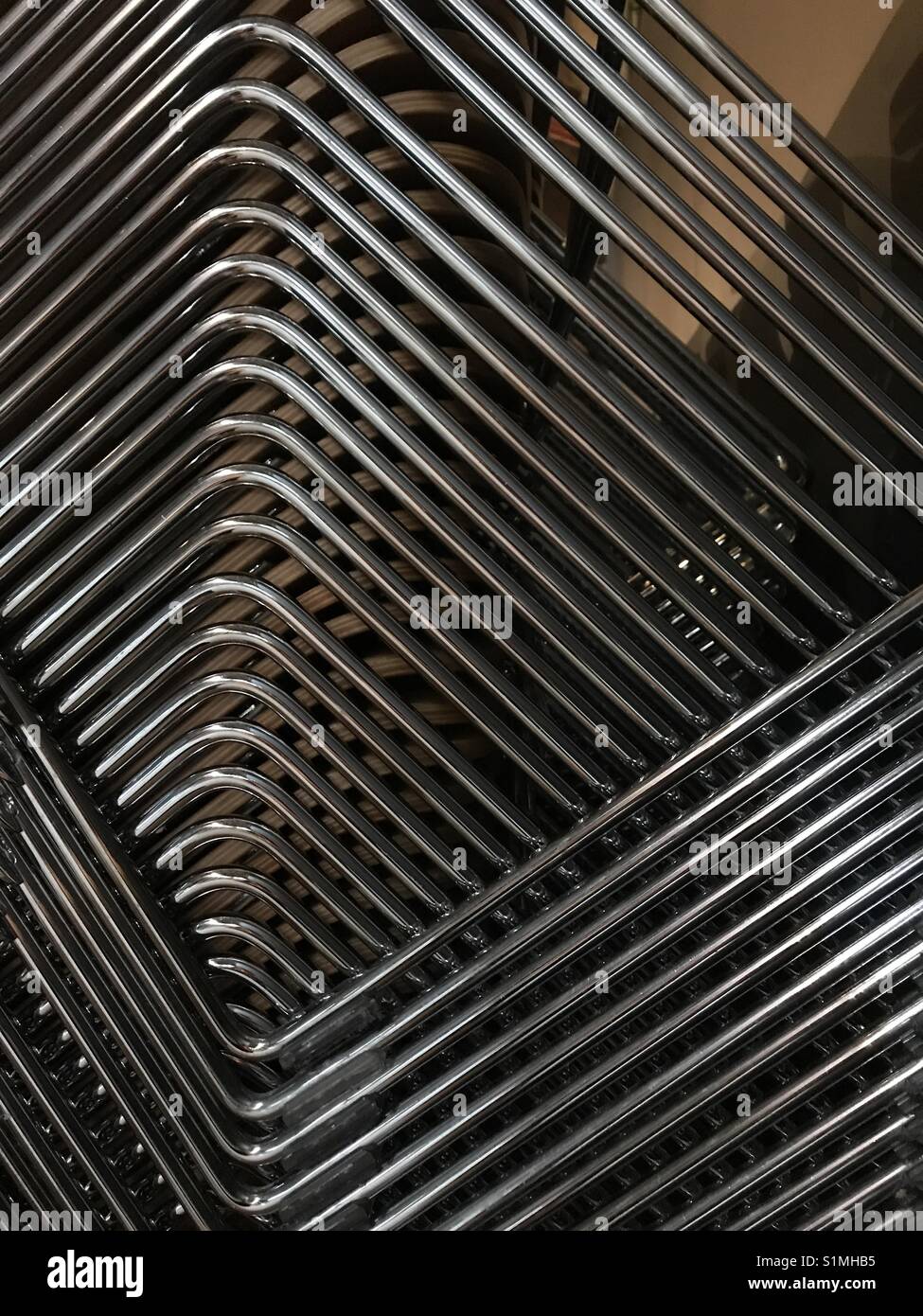 Abstract created by lines and shapes of a stack of metal chairs - Smartphone Captured Stock Image