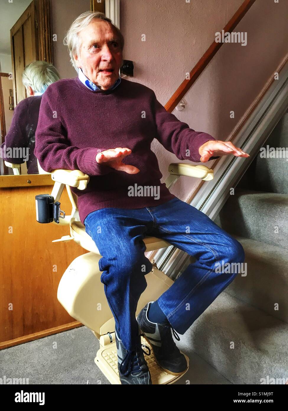 90-year old man using a stairlift in his Suffolk home, UK. - Smartphone Captured Stock Image