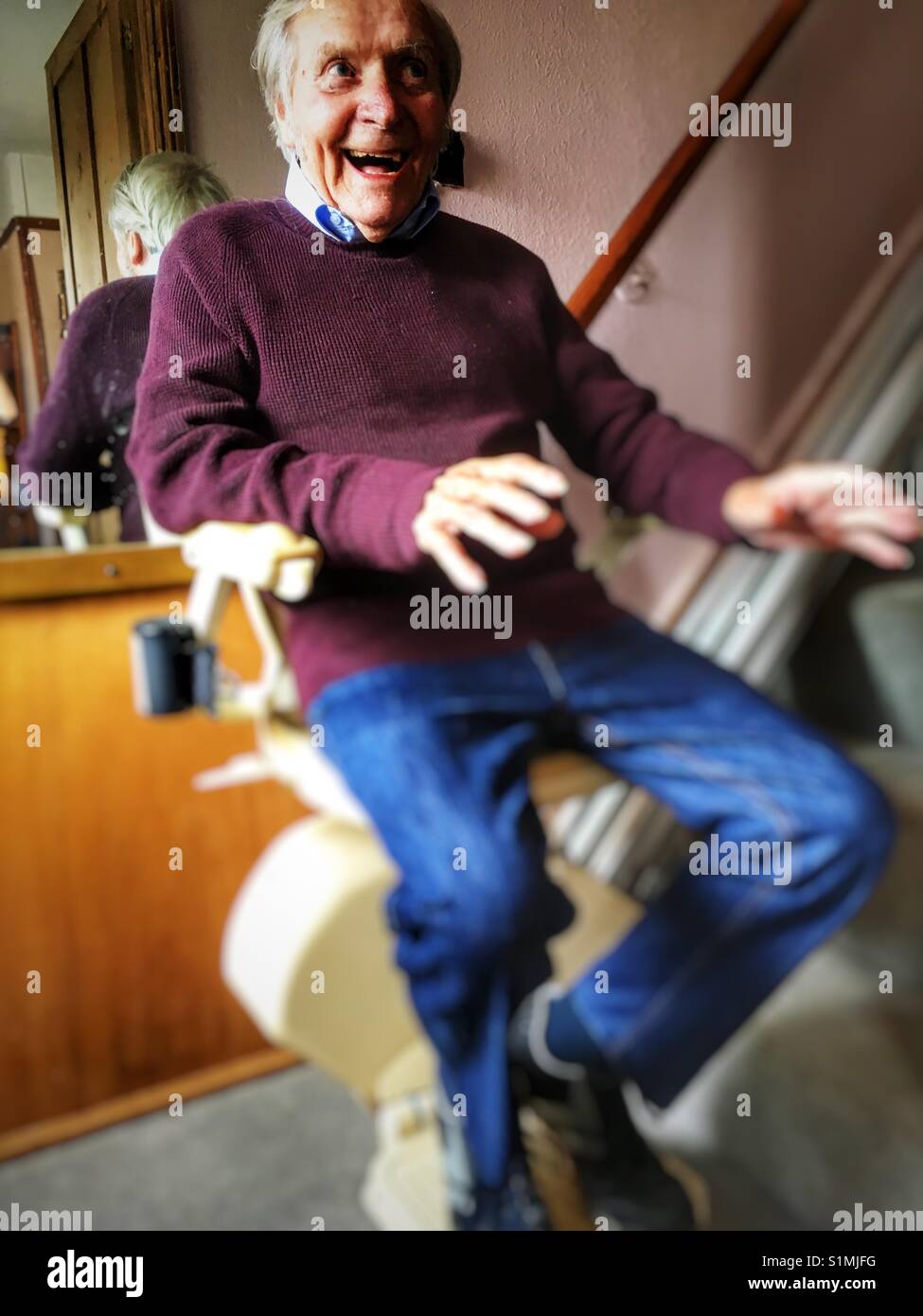 90-year old man using stairlift at home in Suffolk, England. - Smartphone Captured Stock Image