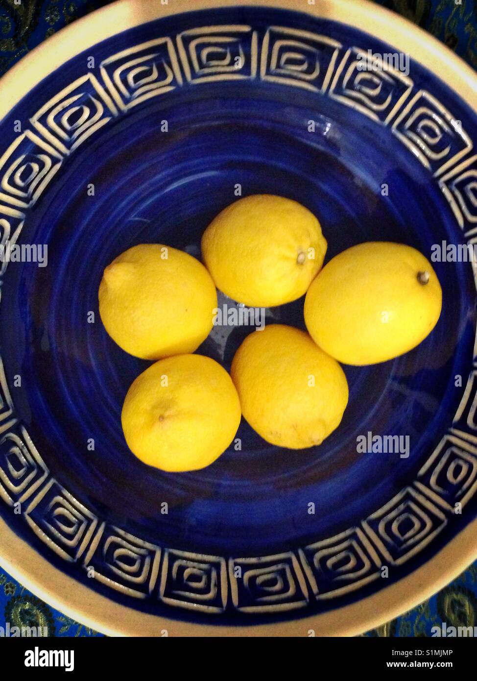 Yellow lemons in a blue bowl Stock Photo