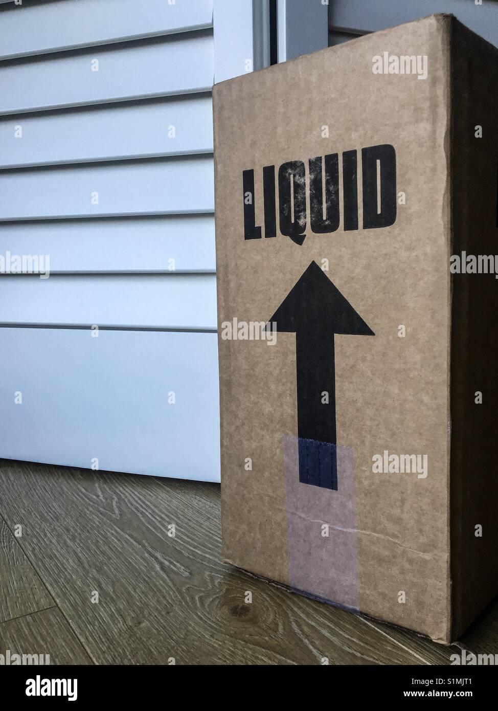Cardboard box with liquid warning label and upwards pointing arrow