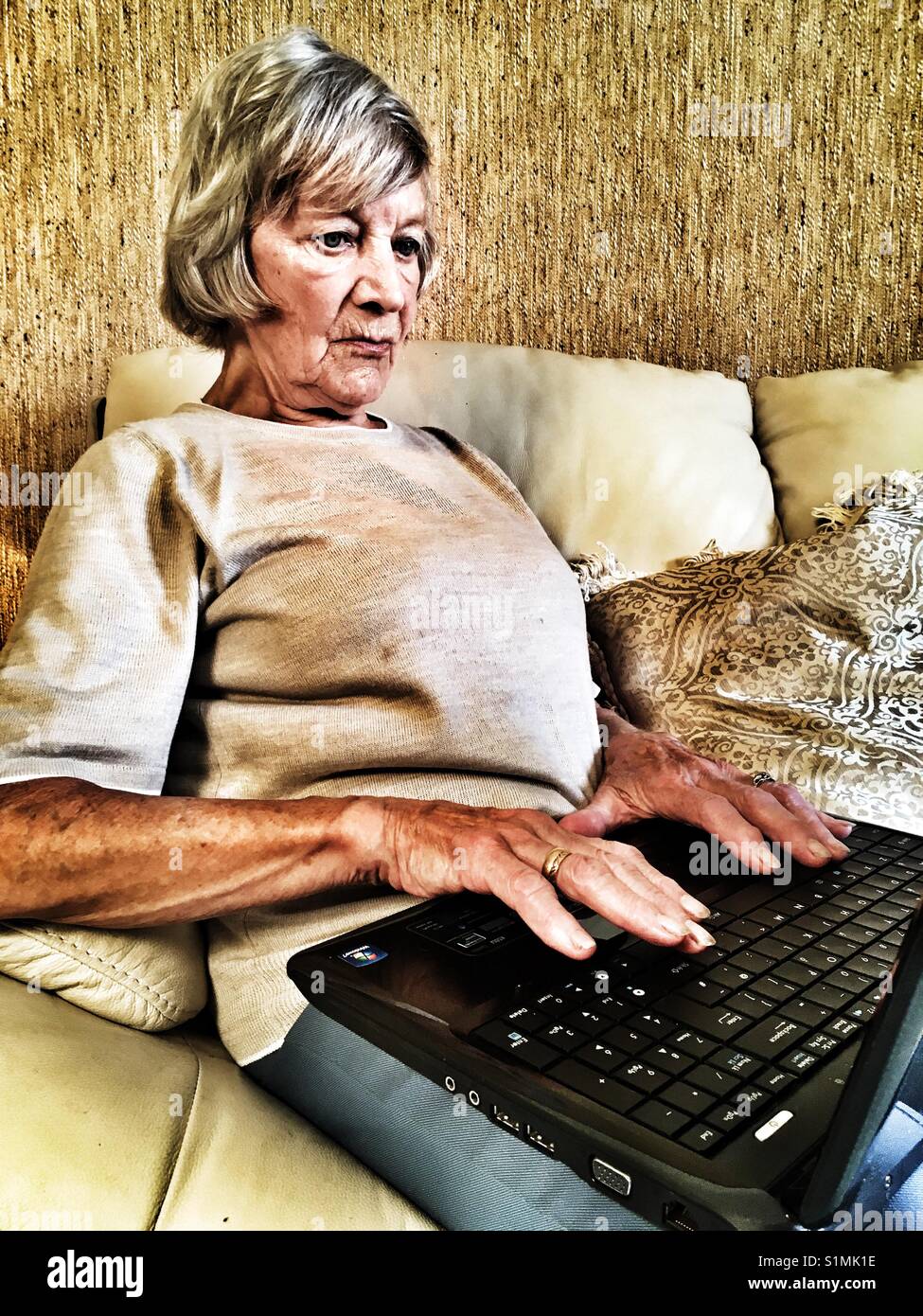Elderly woman using laptop computer - Smartphone Captured Stock Image
