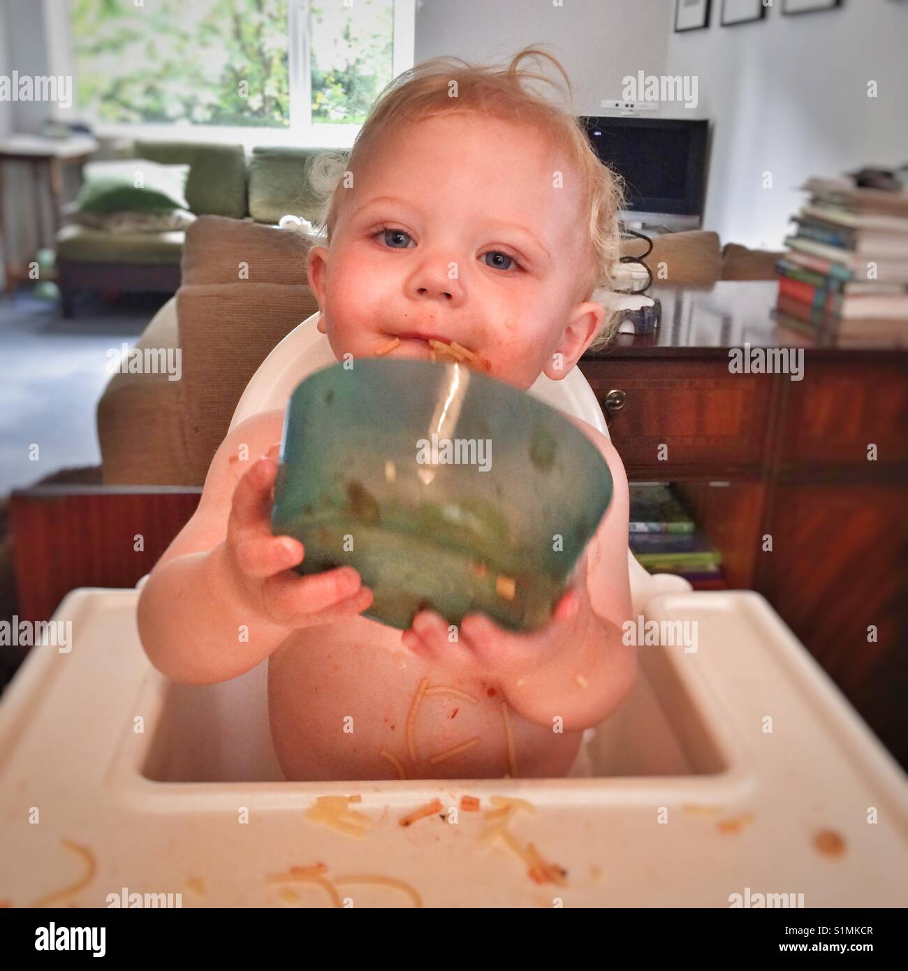 One year old baby boy eating pasta Stock Photo