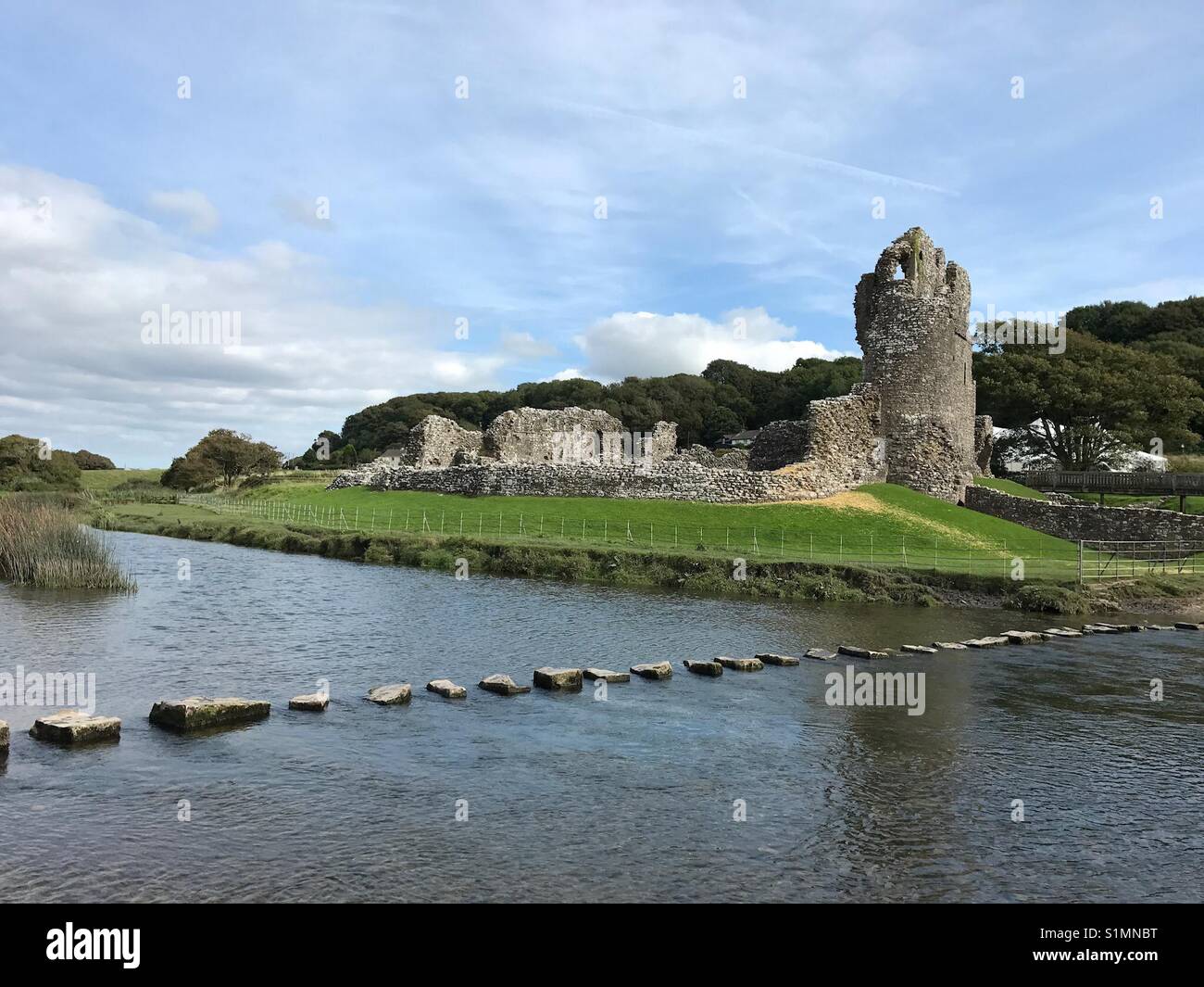 The 12th Century Ogmore Castle, South Wales, with stepping stones across the river Ogmore - Smartphone Captured Stock Image