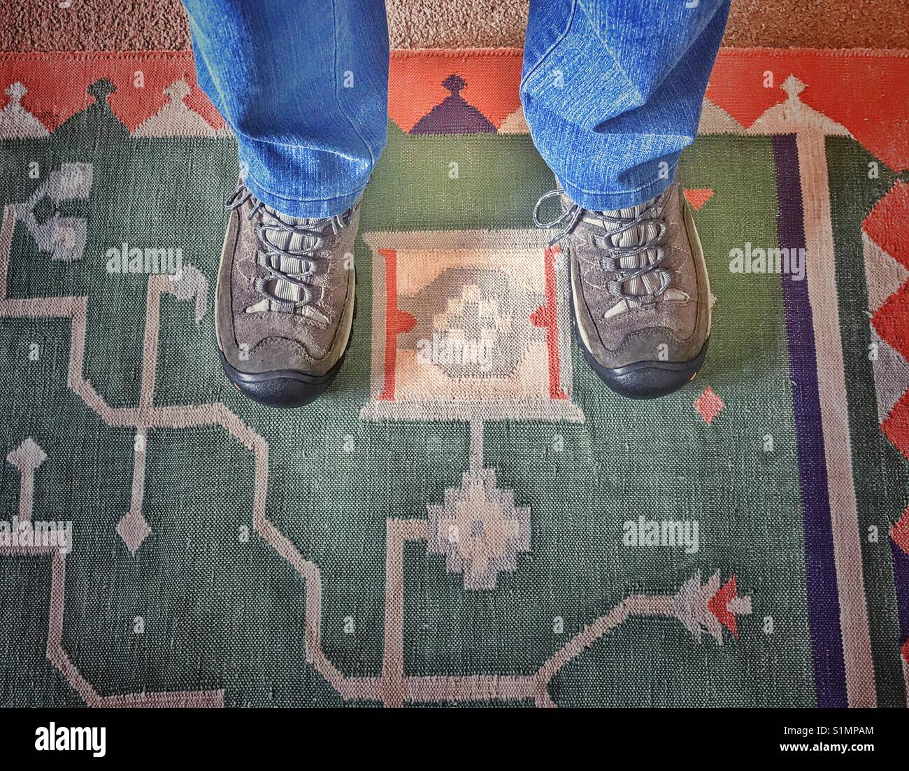 Feet in hiking boots on carpet. Stock Photo