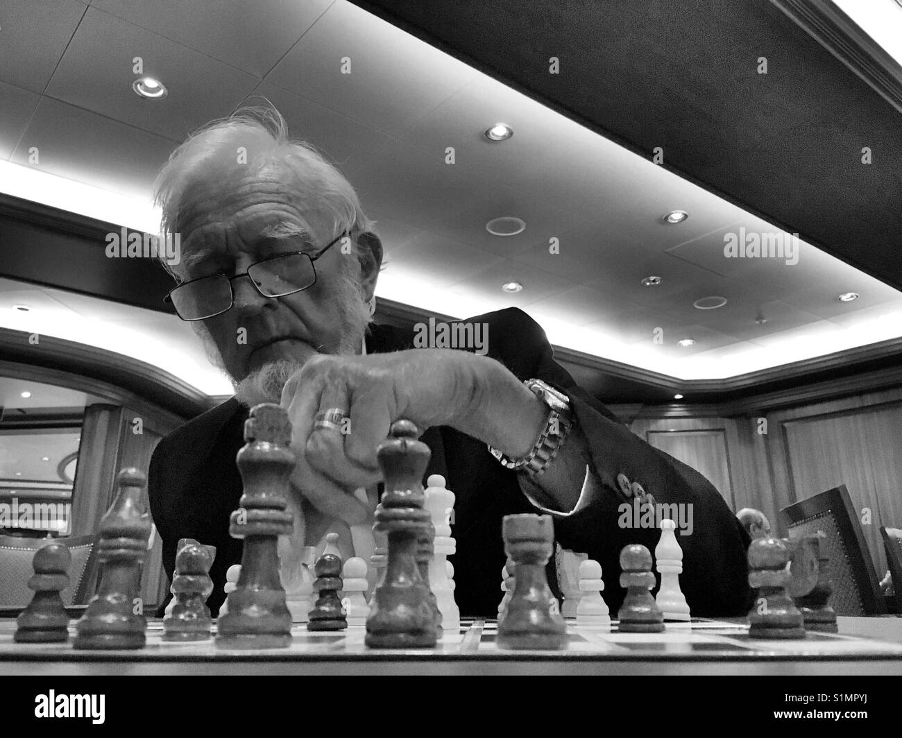 Pensive african american man thinking about next chess move while sitting  at table. Stock Photo by DC_Studio