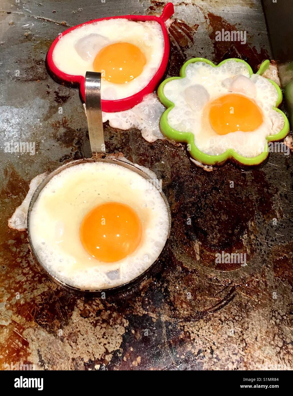 Frying sunny side up eggs on the hot griddle - Smartphone Captured Stock Image
