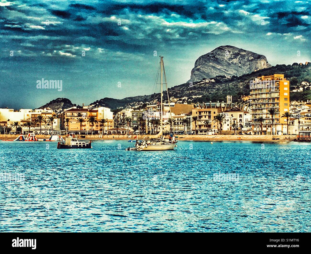 Early morning view of the coast and port area of Javea / Xabia on the Costa Blanca, with Montgo Mountain in the background. Alicante Province, Spain - Smartphone Captured Stock Image