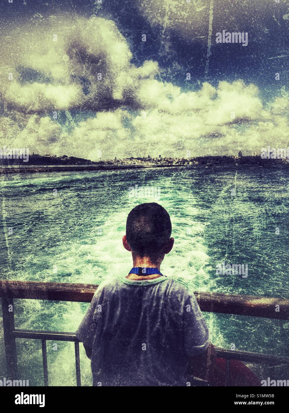 Boy starting at the Bosphorus  water at the rim of the ferry Boat istanbul Turkey - Smartphone Captured Stock Image