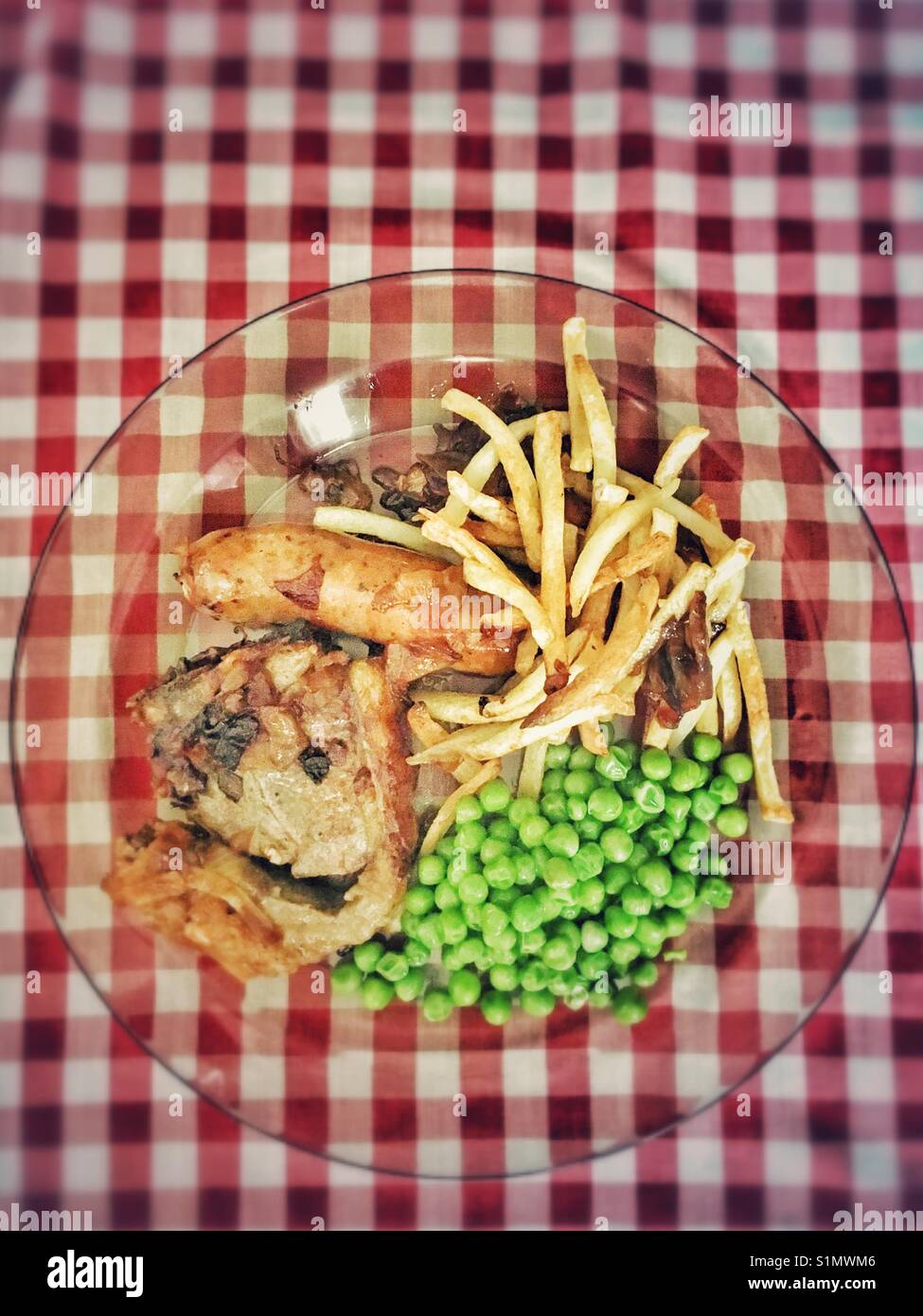 Plate full with lamb, green peas, French fries, caramelised oignon and a sausage. - Smartphone Captured Stock Image