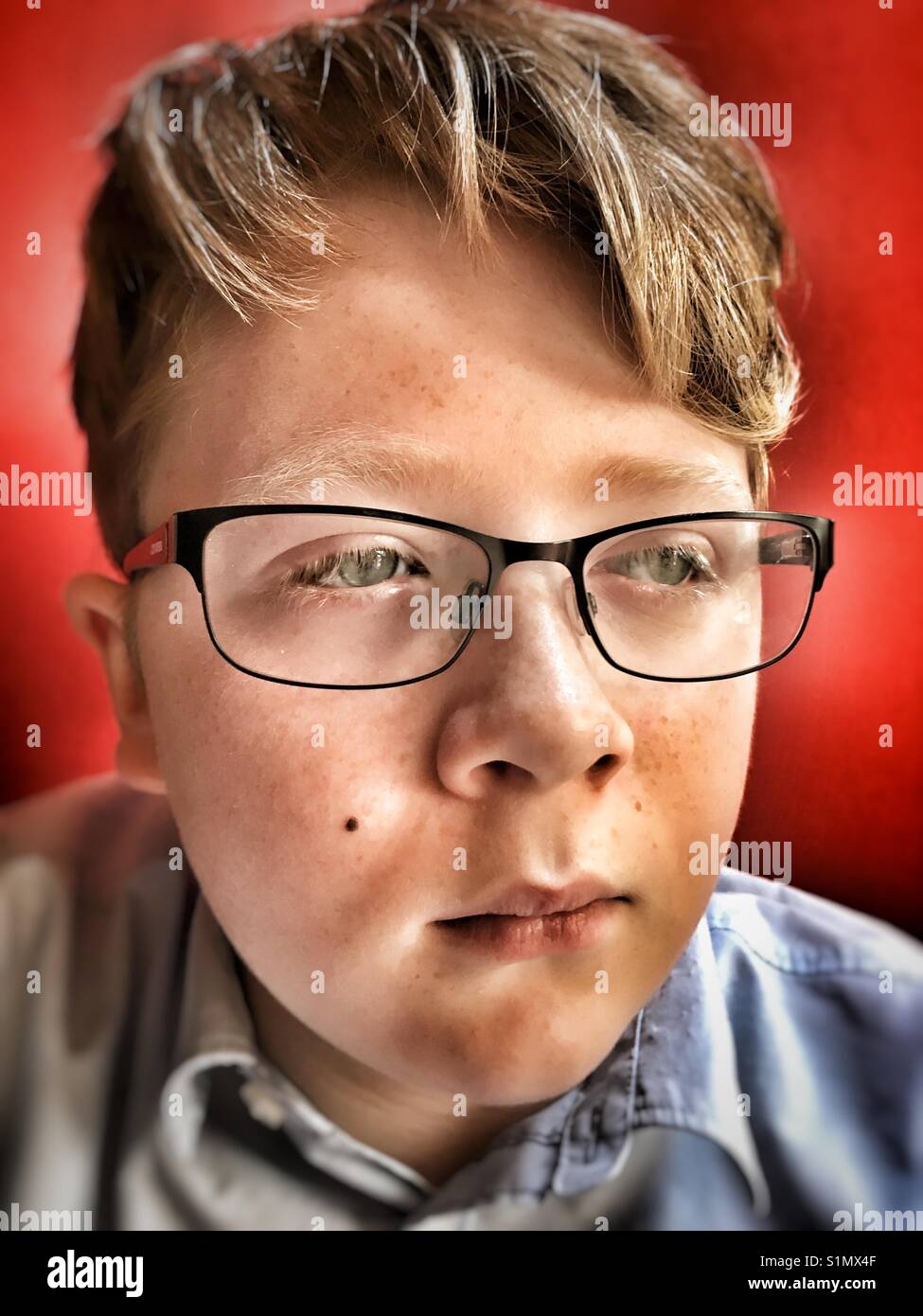 Ginger haired boy wearing glasses Stock Photo