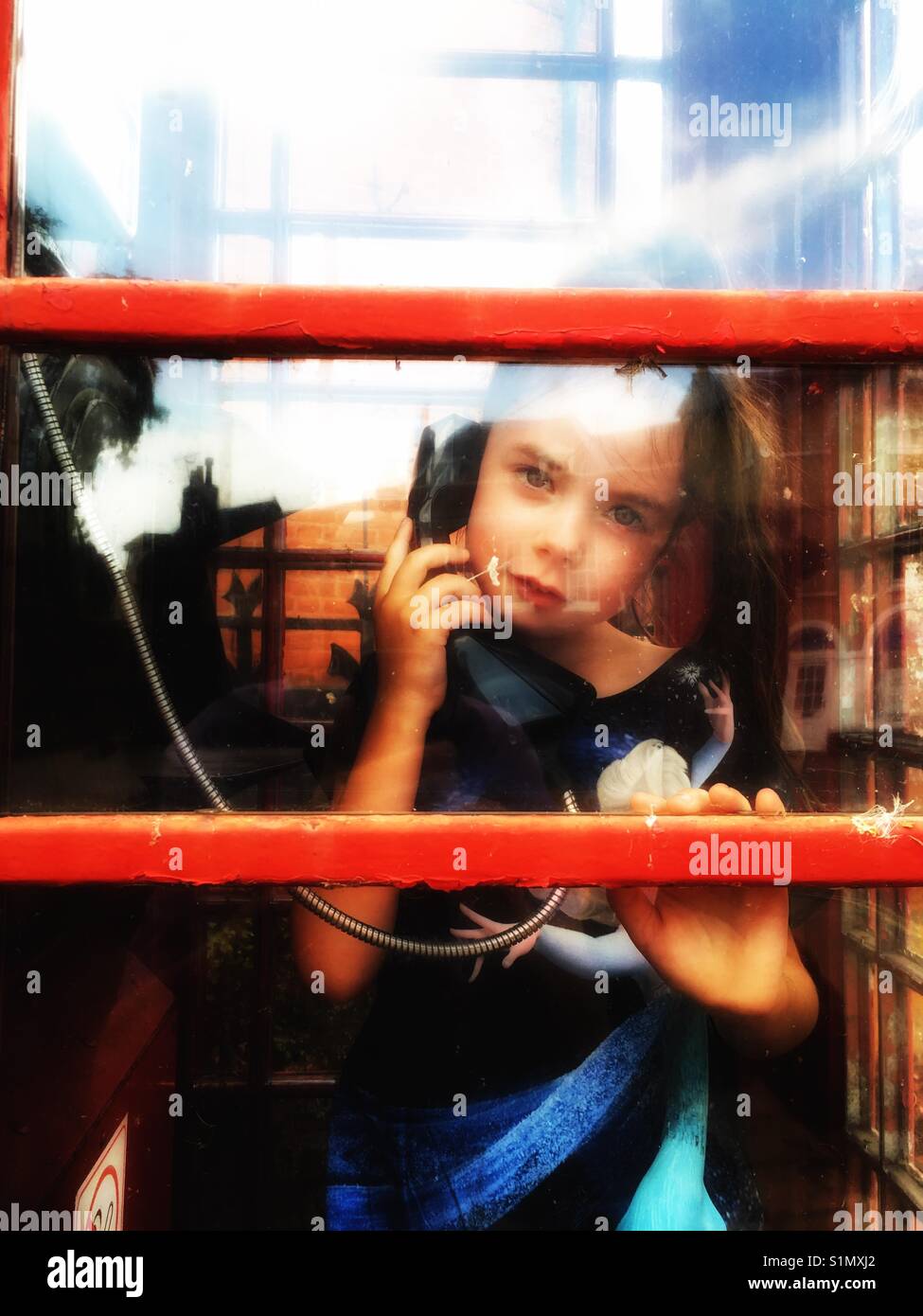Child in public phone box - Smartphone Captured Stock Image