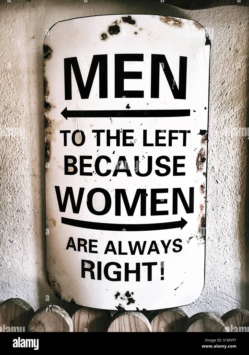 A sign saying men to the left because women are always right Stock