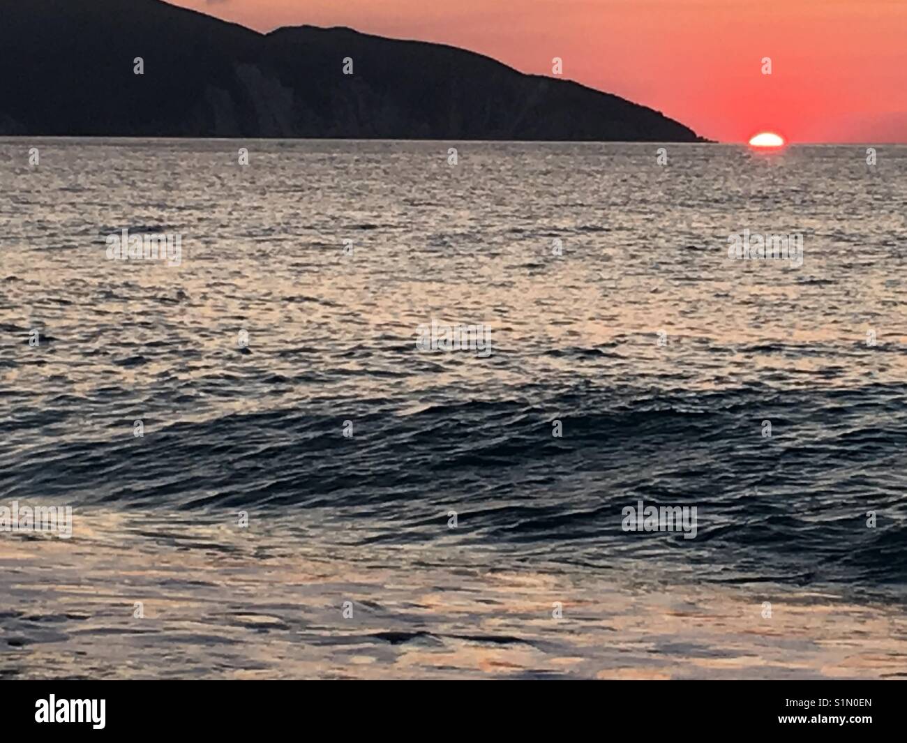 Redsunset on beautiful Myrtos beach that features in Captain Corelli's Mandoline film on Kefalonia, Greek island in Ionian Sea - Smartphone Captured Stock Image