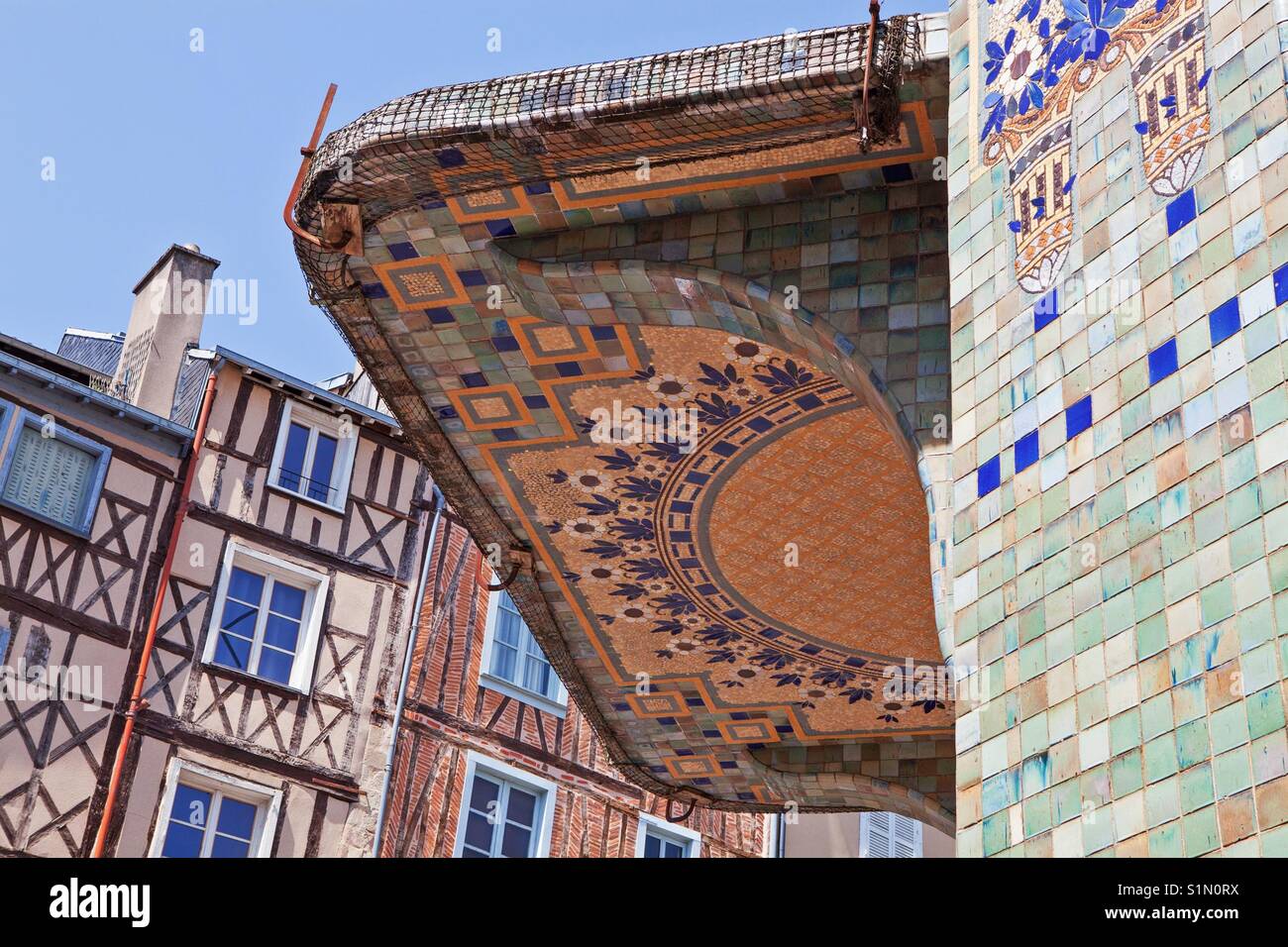 Limoges, Limousin, France: Detail of the mosaic wall and entrance of the Pavillon du Verdurier with old romantic timber-framed houses on the background - Smartphone Captured Stock Image