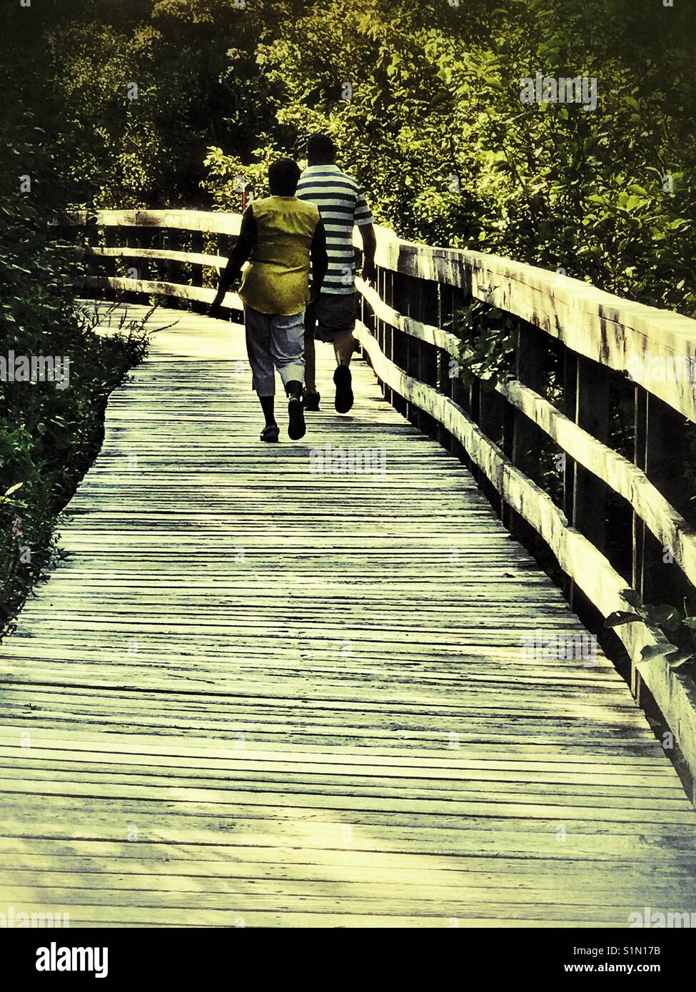 Couple walking on a boardwalk. Stock Photo