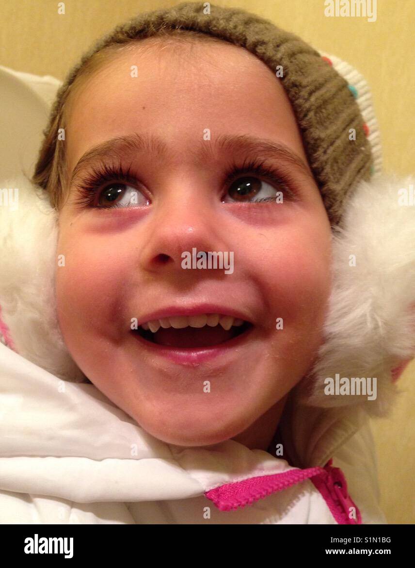 Smiling, cute little girl wearing ear muffs Stock Photo Alamy
