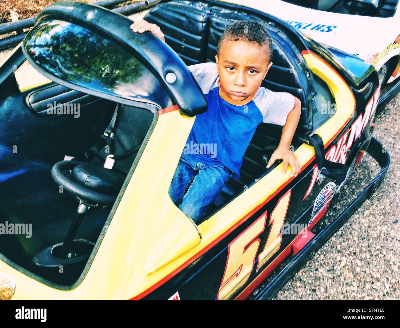 Minnesota State Fair. A sad boy don't want to leave Go Cart attraction - Smartphone Captured Stock Image