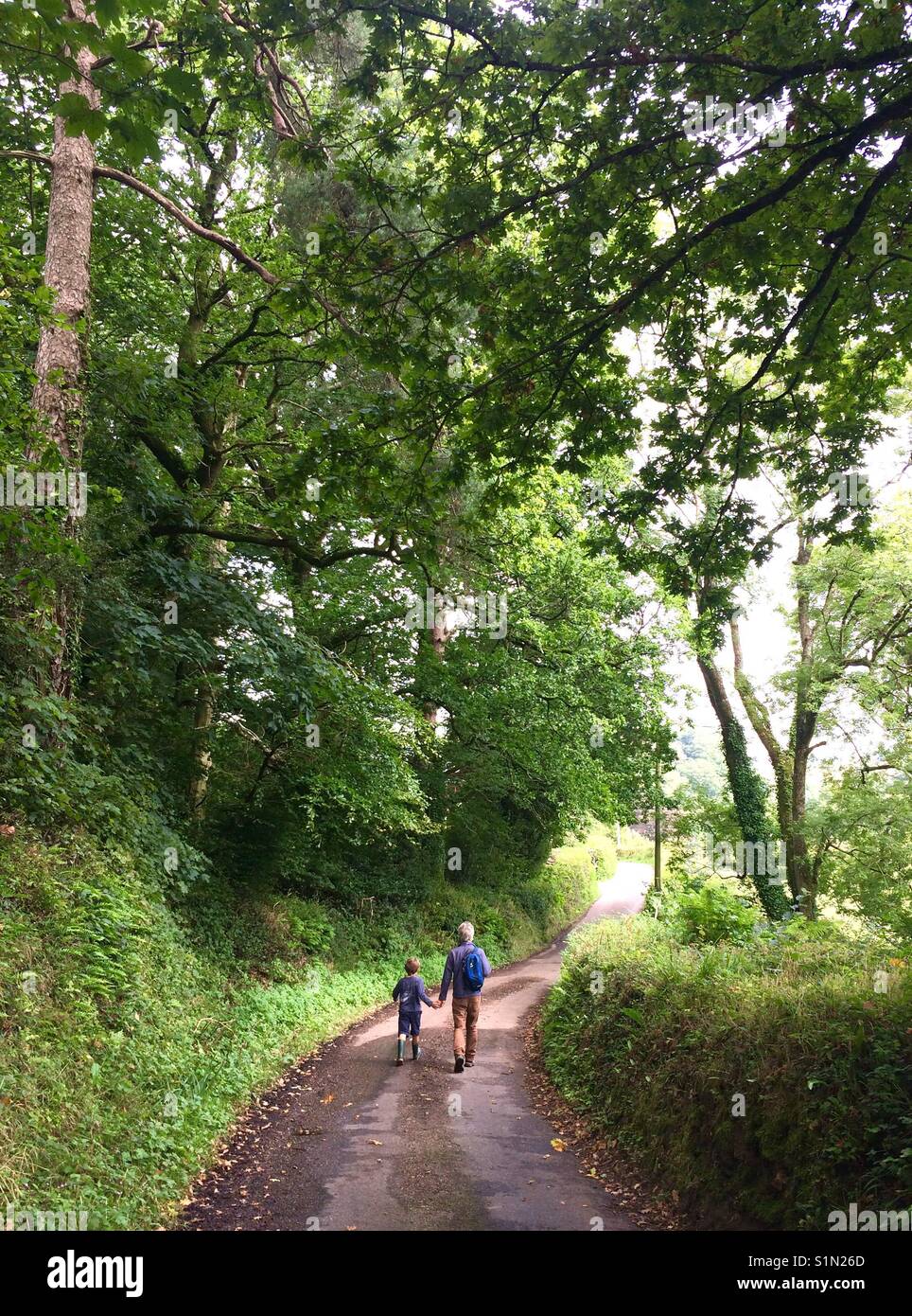 Father and son walking down a country road - Smartphone Captured Stock Image