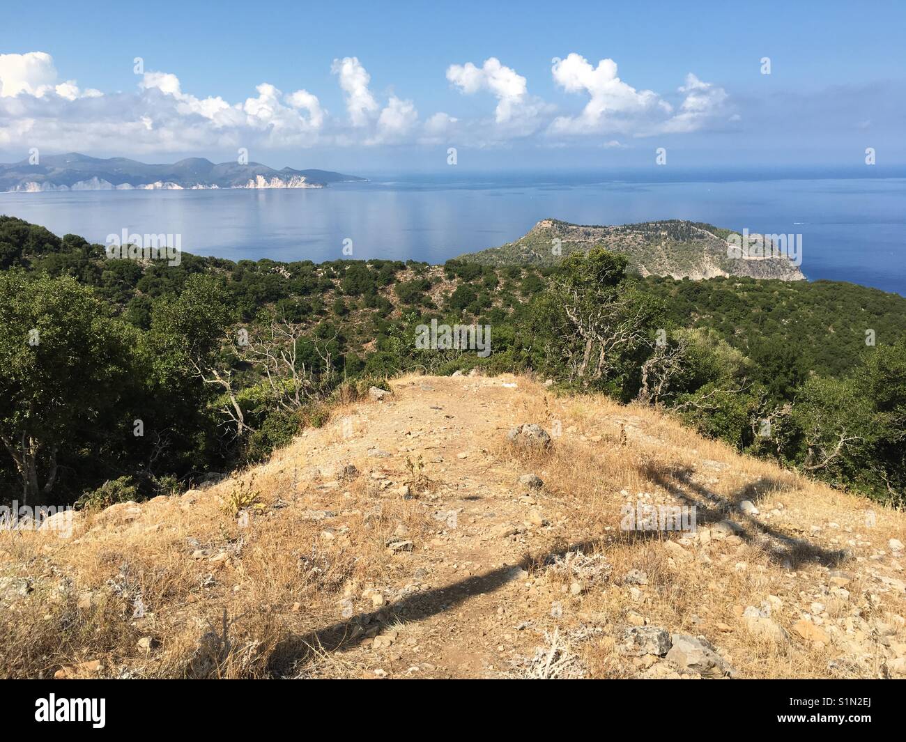 View of Castro in Asos on Kefalonia island in Ionian Sea In Greece with electricity pylon cross like shadow and lots of pine reees - Smartphone Captured Stock Image
