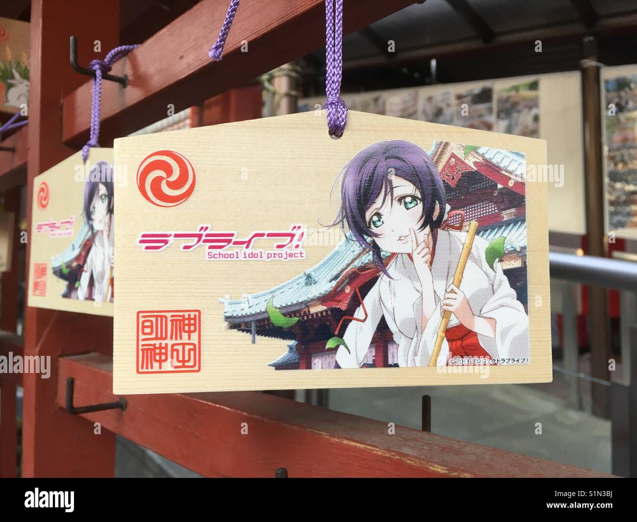 A wooden wishing plaque inside Kanda Myojin Shrine in Tokyo. Unofficially known as the 'Love Live!' shrine, the plaque features a character from the popular animation dressed as a shrine maiden. Stock Photo