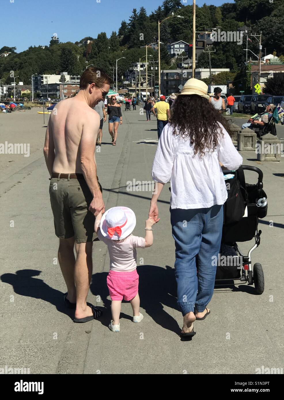 Couple walks their young child along the waterfront, summer in Seattle Stock Photo
