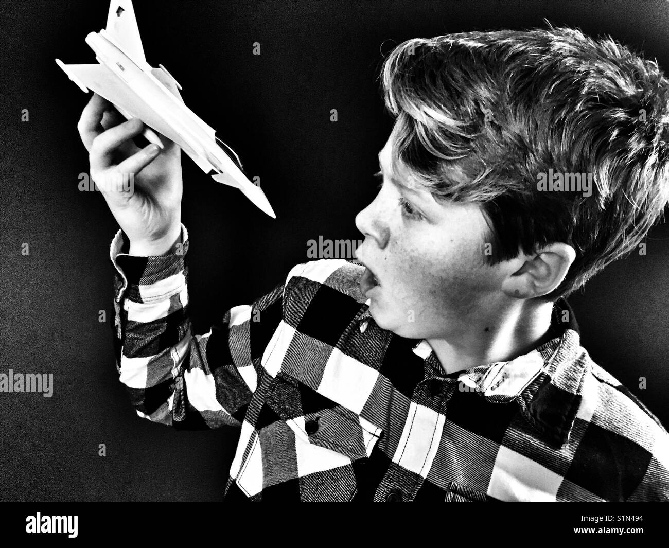 Boy playing with a model jet fighter - Smartphone Captured Stock Image